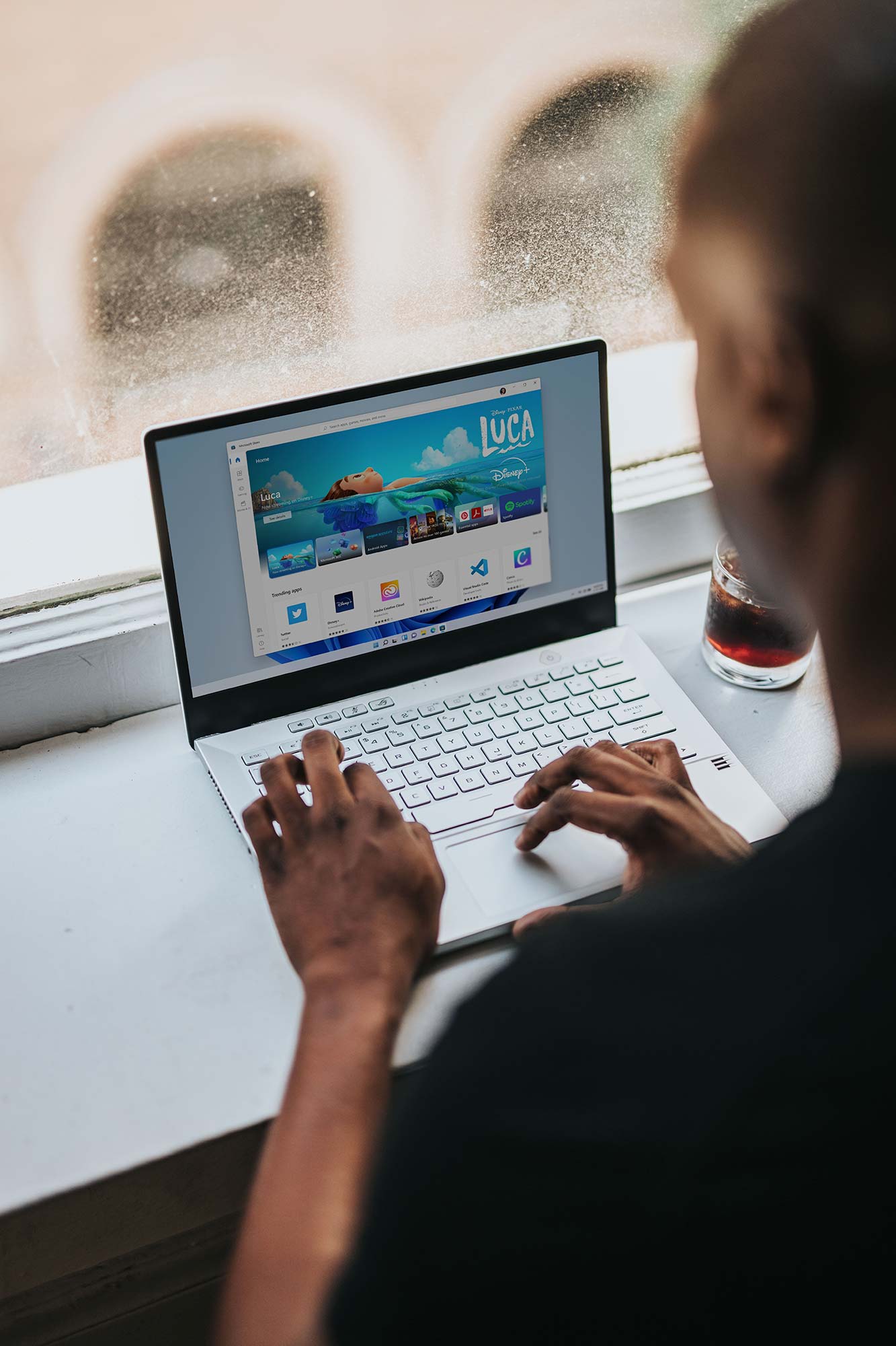 Person at a laptop with books nearby, writing an email