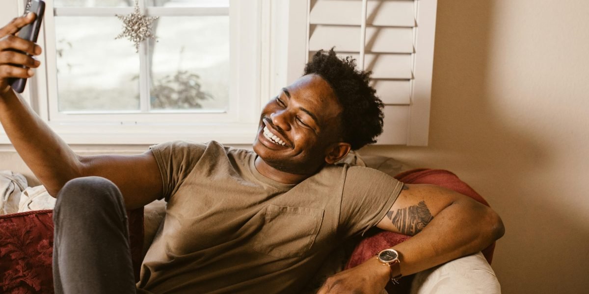 A person smiling warmly while watching a humorous dog video, reflecting the joy these pets bring.