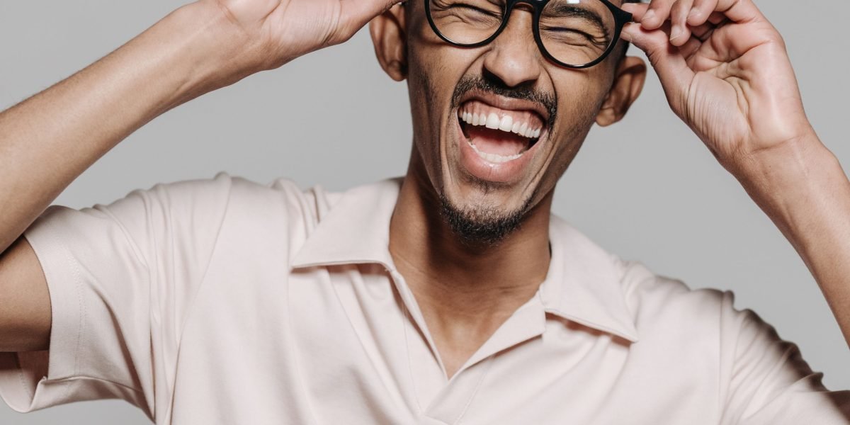 A person genuinely laughing with visible joy, capturing the immediate emotional response to visual humor.
