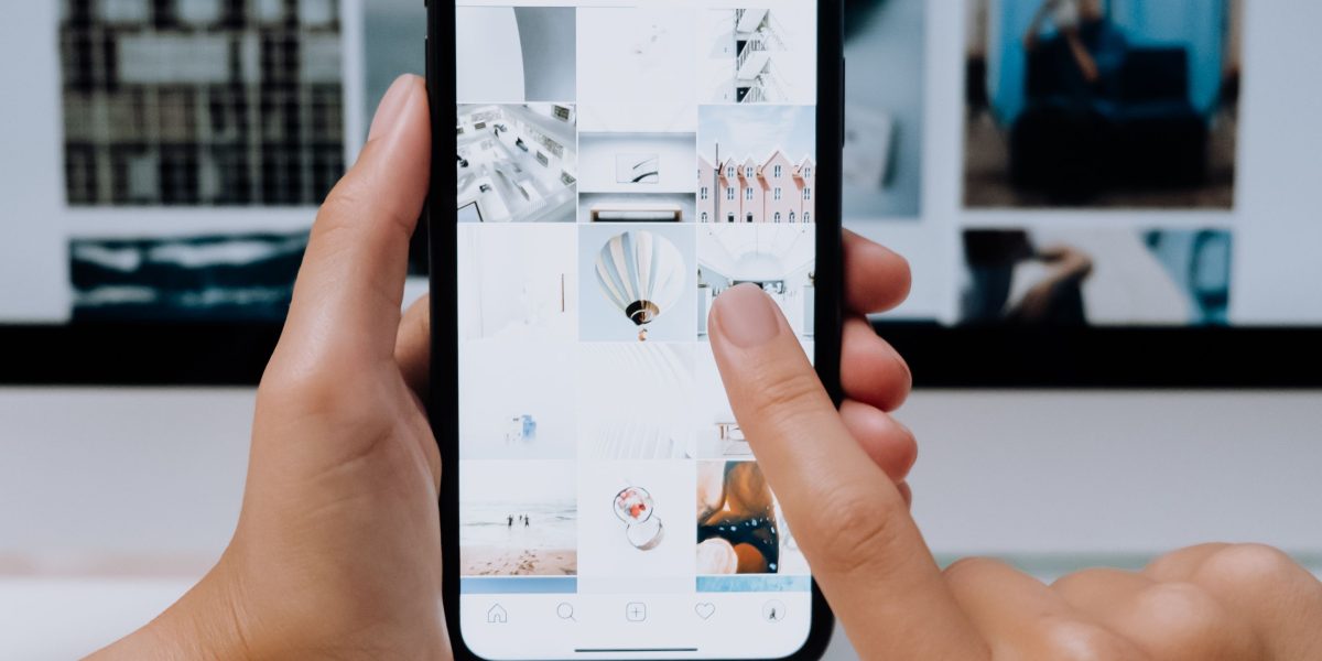 A person actively engaging with their mobile device, representing the widespread sharing and virality of funny images and memes.