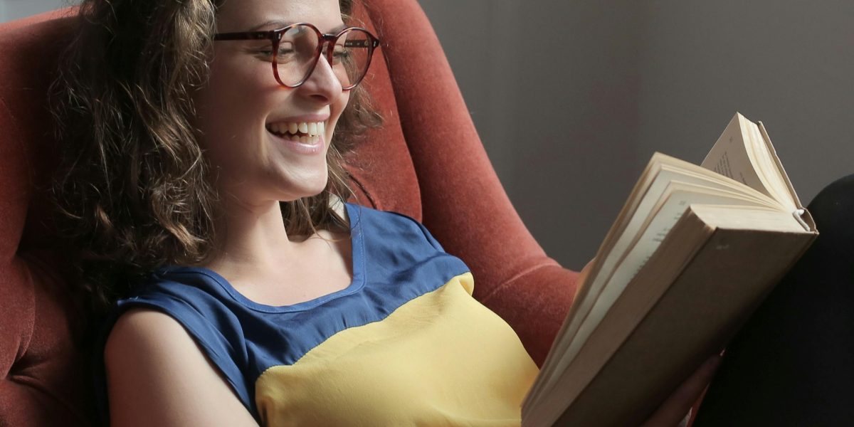 A person enjoys a humorous story, demonstrating the power of animal characters to evoke laughter.